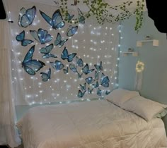 a bed with white sheets and blue butterflies on the wall