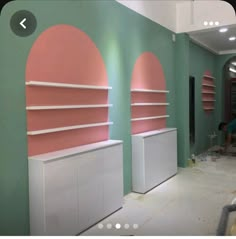 the room is being painted with pink and green walls, along with shelving units