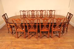 a dining room table with six chairs and a large oval wooden table surrounded by wood flooring