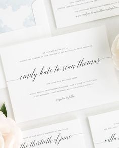 the wedding stationery is laid out on top of each other with flowers in front