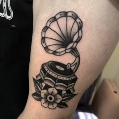 a black and white photo of a tattoo on someone's leg, with an object in the background