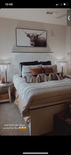 a large bed sitting in a bedroom next to two nightstands and a painting on the wall