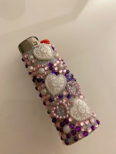 a cell phone covered in lots of beads and sequins on a white surface