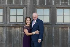 a man and woman standing next to each other in front of a building with windows