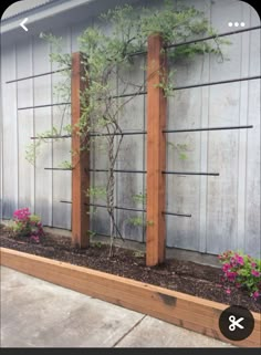 a wooden planter filled with plants next to a building