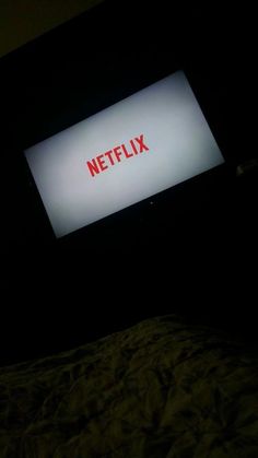 the netflix sign is lit up in the dark, and it appears to be red