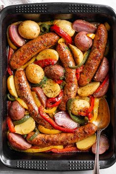 sausages, potatoes and peppers in a pan with a serving spoon on the side