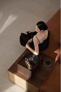 a woman sitting on top of a couch next to a table with a record player