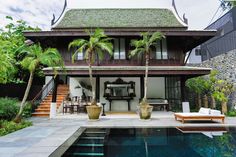 a house with a pool in front of it and palm trees on the other side