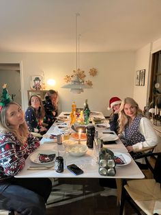 a group of women sitting at a table with food and drinks in front of them