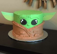 a cake that looks like the child yoda from star wars on top of a table