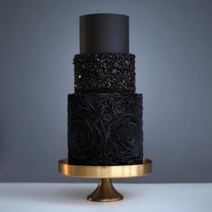 a black and gold wedding cake with roses on the top is featured in instagram