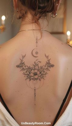 the back of a woman's neck with flowers and a crescent tattoo on it