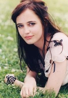 a woman laying in the grass with her hands on her hips and looking at the camera