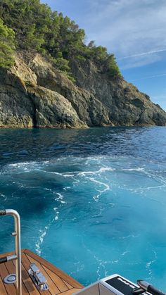 there is a boat in the water near some cliffs