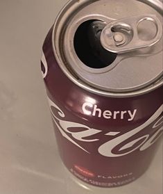 a can of cherry soda sitting on top of a table