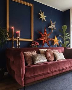 a living room with blue walls and red couch in front of a large star decoration on the wall