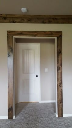 an empty room with a door and carpeted floor