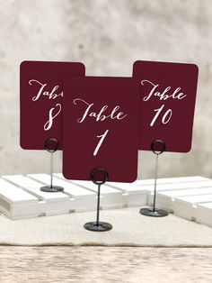 two red place cards with white calligraphy on them