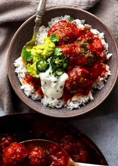 a bowl filled with rice and meatballs next to a spoon full of sauce on the side