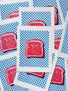 four square pieces of red food sitting on top of blue and white checkered paper