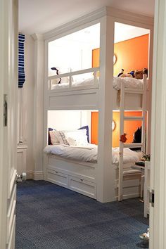 there are bunk beds in this room with blue carpet and white walls, along with other furniture