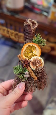 a person holding up a piece of fruit with cinnamons and orange slices on it