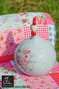 a decorative vase sitting on top of a patchwork quilted blanket in the grass