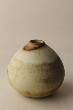 a white and brown vase sitting on top of a table