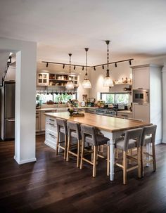 a large kitchen with wooden floors and white walls, along with lots of counter space