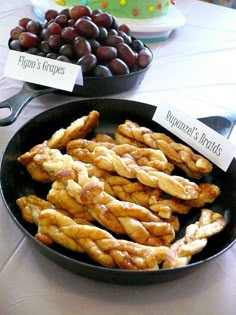 there are some grapes and other foods on the table with name tags in front of them