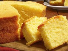 several pieces of yellow cake sitting on top of a cutting board next to a knife