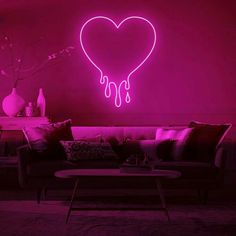 a living room filled with furniture and a neon heart wall decal on the wall