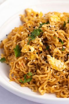 a white plate topped with noodles covered in sauce and garnished with parsley