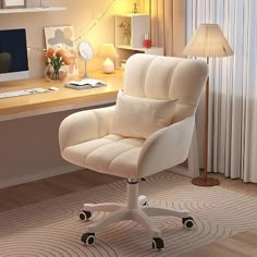 a white office chair sitting in front of a desk with a computer on top of it