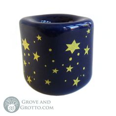 a blue cup with gold stars painted on the outside and inside, sitting in front of a white background