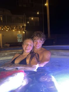 two people in a pool at night