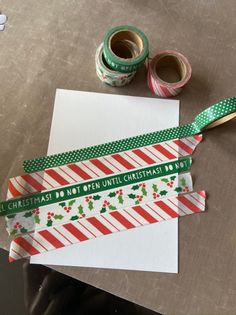 two rolls of washi tape sitting on top of a piece of paper next to some scissors