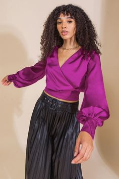 The MY HERO WOVEN SATIN TOP is a stylish addition to your wardrobe. It features a surplice neckline with snap button closure, long sleeve with cuff, and pleated front waist band and smocked back waist band for a flattering fit. This solid woven satin top is perfect for any occasion. Details Self: 100% Polyester Size & Fit - Model is 5`8" And Wearing Size Small - Measurements Taken From Size Small - Approx. Length: 16" Purple Blouse Outfit, Moonlit Winter, Satin Top Outfit, Magenta Top, Dinner Gown, Beef Empanadas, Bright Winter, Satin Blouses, Purple Blouse