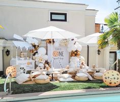 an outdoor dessert table set up with white and gold balloons