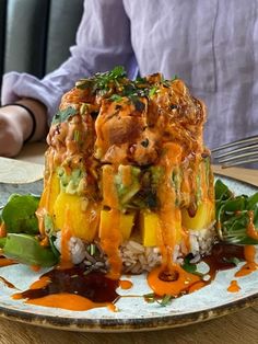 a person sitting at a table in front of a plate of food with rice and vegetables on it