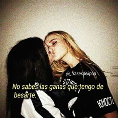 two women kissing each other in front of a white wall with the words, no sabes las ganas que tengo de besarre