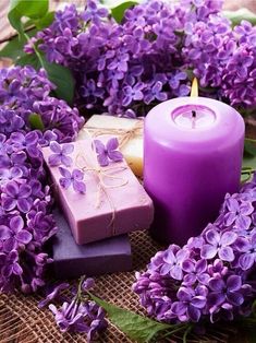 purple candles and soaps are surrounded by flowers