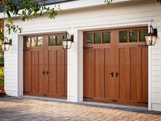 two brown garage doors in front of a white house