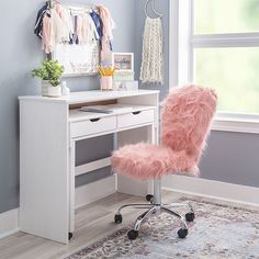 a pink chair sitting in front of a white desk