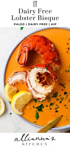 a bowl of lobster bisque with lemons and garnish on the side