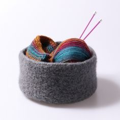 there is a yarn ball and needles in the bowl