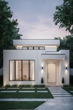 a white modern house with large windows and lights on the front door is lit up at night