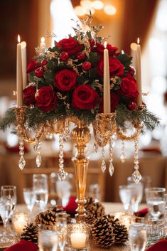 a centerpiece with red roses and pine cones sits on a table set for a formal dinner