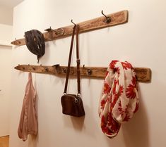 several purses and hats are hanging on the wall next to coat racks with hooks